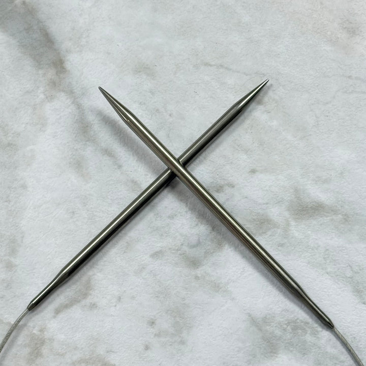 Lykke 40" Fixed Circular Surgical Stainless Steel Knitting Tips on a Marble Background. 