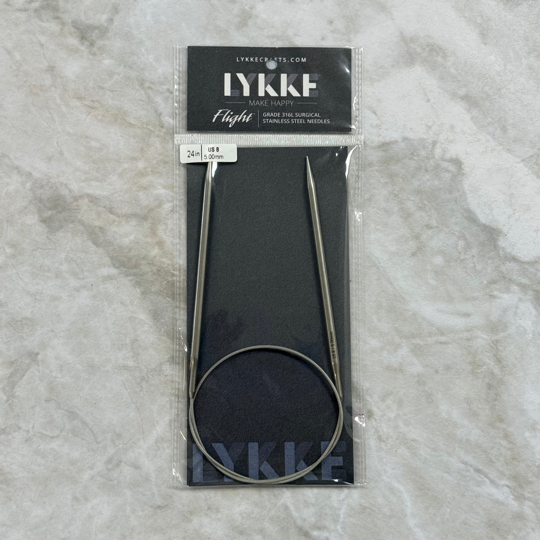 A package of LYKKE circular knitting needles, size 24, in a clear plastic sleeve with a black header card, placed on a light gray marble surface.