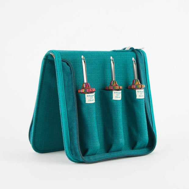Teal carrying case with three punch needles on a white background
