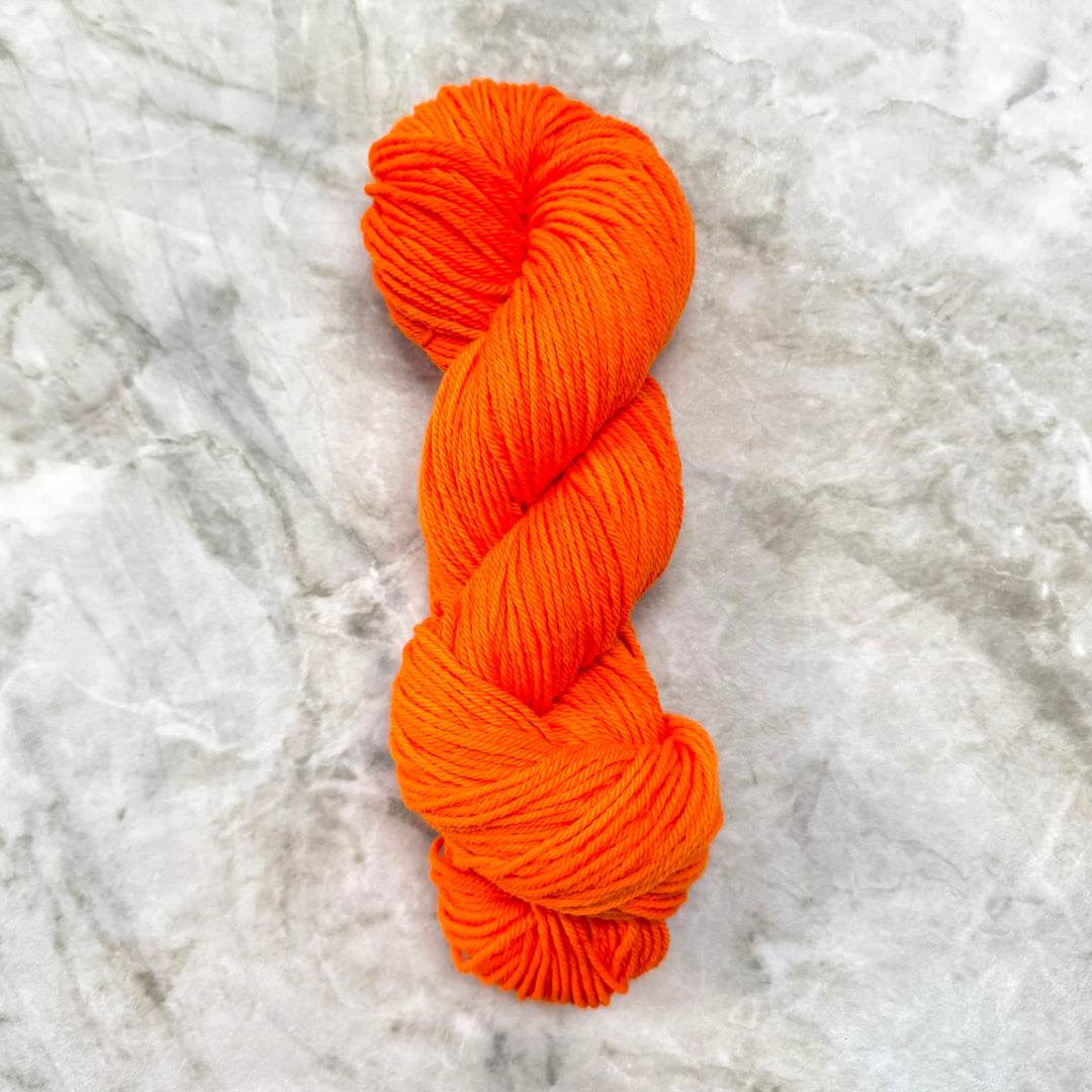 Orange skein of yarn on a marble surface