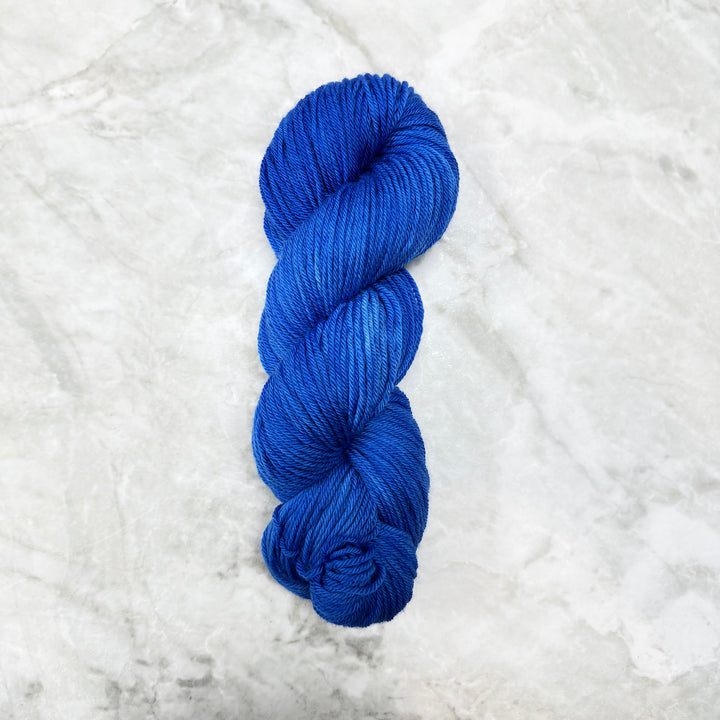 Blue skein of yarn on a textured white background