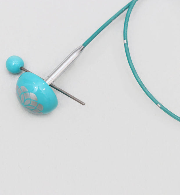 Strong and flexible - made of finest grade material.  Smooth coated and teal in color.  Allows your interchangeable tips to swivel freely.  Memory free cord for no twisting.  Marked at 1" intervals for convenient measuring.  Offered with teal colored end caps with the floral print are a delight to use and the cord keys used for tightening the tips to the cord come with a color coordinated top.  The Mindful Collection Smart Cords will work with all Knitter's Pride needles.  Comes with 1 cord key & 2 end caps